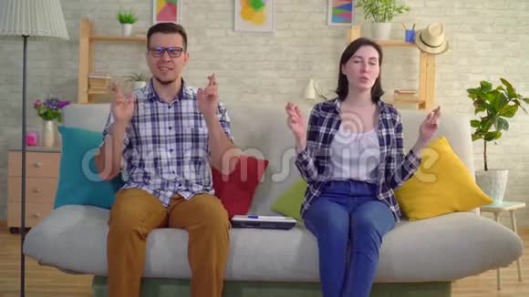 年轻的已婚夫妇坐在客厅里在积极的怀孕测试中感到高兴视频的预览图