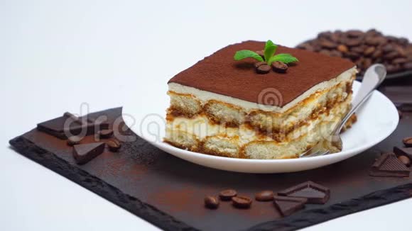 提拉米苏甜点部分巧克力棒和咖啡豆在石头上提供切割板视频的预览图