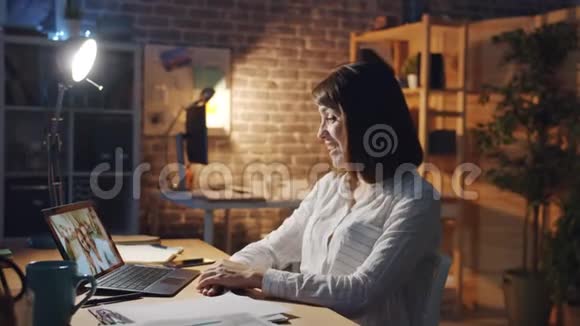 快乐的女孩在办公室里和朋友用手提电脑聊天视频的预览图