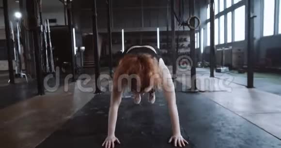 年轻漂亮的红发白种人女运动员在健身房慢动作的功能锻炼中做汉堡运动视频的预览图