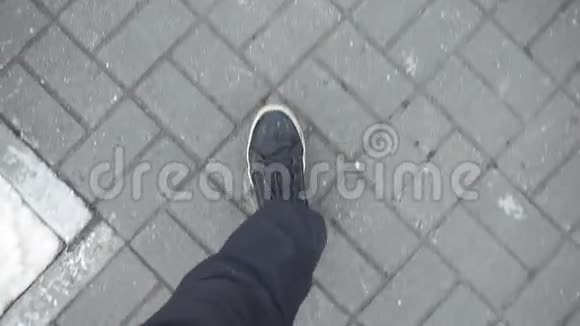 穿着黑色运动鞋的人走在人行道上街上铺着瓷砖视频的预览图