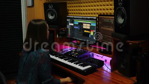 女歌曲作者混合和掌握在数字音频工作站音响工程师在家庭音乐工作室工作配备显示器和视频的预览图
