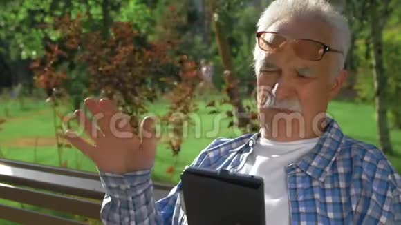 有胡子的老人懂得如何打开平板电脑的应用程序视频的预览图