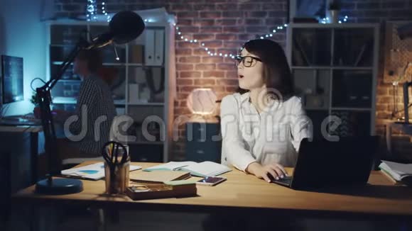 一幅妇女在办公室里向同事求助电脑谈话的画像视频的预览图