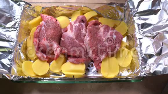 在生土豆和猪肉脖子上放洋葱切环视频的预览图