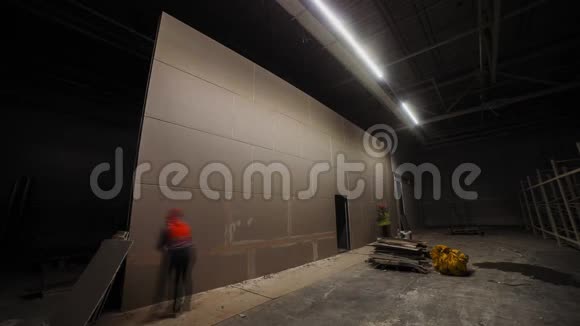 专业建筑工人在黑暗的仓库里用砌块墙施工视频的预览图