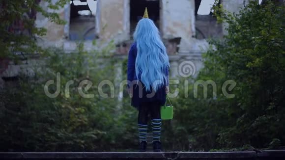 带着蓝色头发的小女孩的后景穿着独角兽的万圣节服装带着糖果可怕的房子视频的预览图
