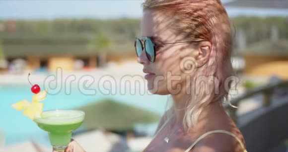 在假期里享受绿色鸡尾酒的女人视频的预览图