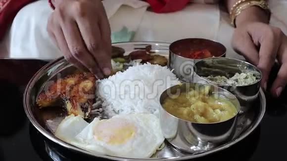 近距离拍摄一只手用米饭鱼和吃一只非素食的印度塔利人视频的预览图