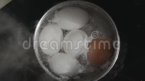 鸡蛋用不锈钢锅煮水开始沸腾鸡蛋被许多小空气覆盖视频的预览图