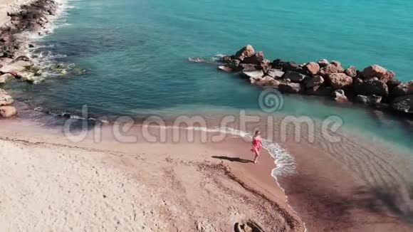 沙滩上漂亮的女孩迎风招展的女人沙滩上的裙子穿着白色沙滩和蓝色沙滩的可爱女人视频的预览图