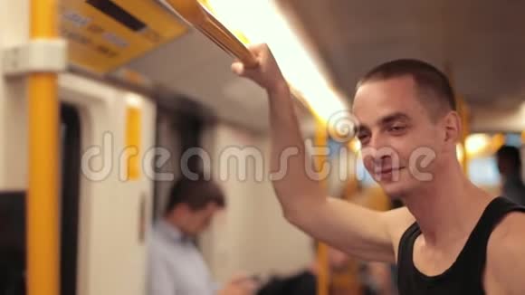 穿黑色衣服的年轻人坐地铁扶着黄色的扶手视频的预览图