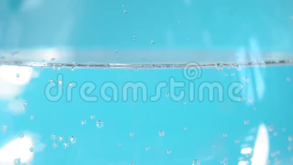 蓝色液体苏打水在玻璃玻璃特写气泡选择性聚焦背景视频的预览图
