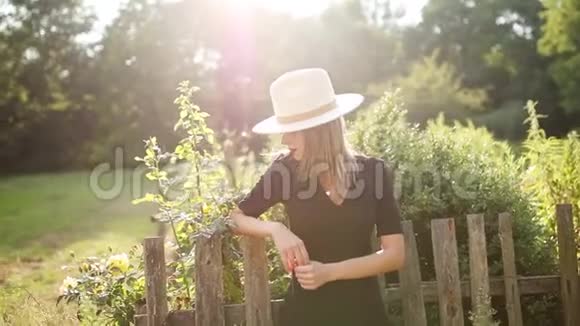 戴帽子的女人在夏天的乡村花园视频的预览图