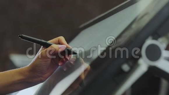 在图形平板上画画设计师在一个图形平板上画画使用交互式笔显示特写视频的预览图