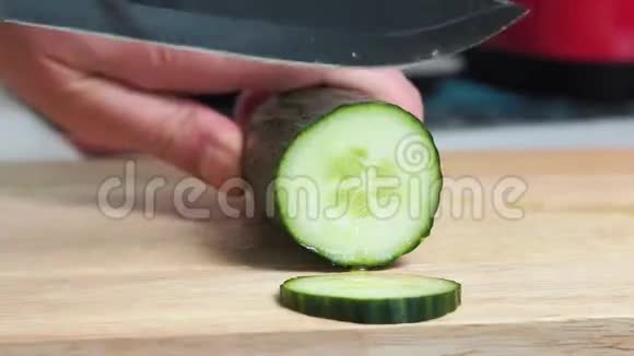 用刀切蔬菜做饭雄性手切新鲜黄瓜的特写镜头视频的预览图