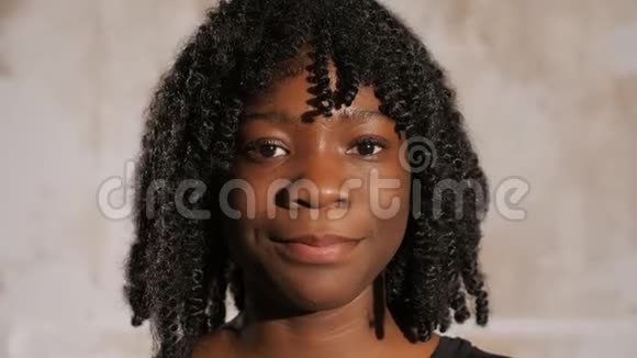 一位留着卷发的非裔美国女孩微笑着向前看视频的预览图