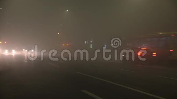 汽车在雾蒙蒙的道路上夜间能见度差空气污染汽车在浓雾中在城市的街道上行驶困难和极端视频的预览图