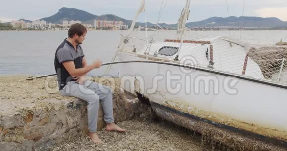那个人在暴风雨过后绝望地坐在游艇旁视频的预览图