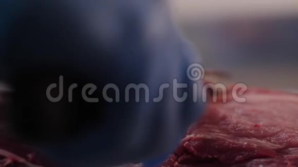 穿蓝色手套的屠夫用刀切猪肉视频的预览图