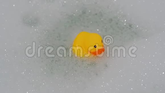 橡皮黄鸭玩具用泡沫在浴缸中漂浮视频的预览图