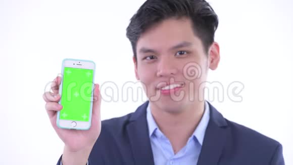 一位年轻快乐的亚洲商人的脸上挂着电话竖起大拇指视频的预览图