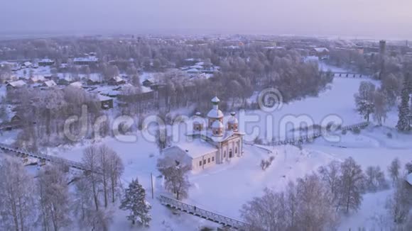 早晨下雪飞过村庄东正教教堂空中摄影4K视频的预览图