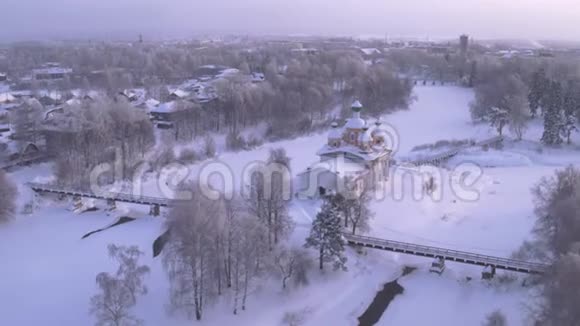 白雪皑皑的早晨飞过村庄东正教教堂空中摄影4K视频的预览图