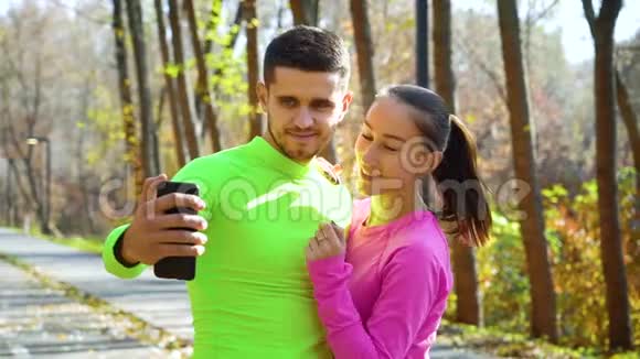 微笑运动情侣在秋季公园自拍视频的预览图