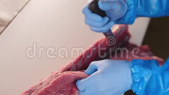 工人在车间的桌子上用刀把新鲜的肉装上视频的预览图