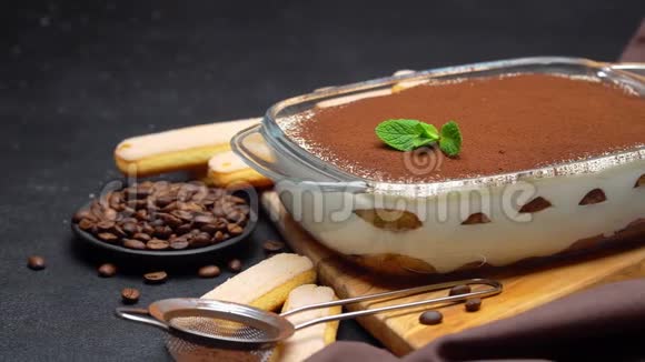 木制木板上的玻璃烤盘上的提拉米苏甜点和混凝土背景上的萨沃亚迪饼干视频的预览图