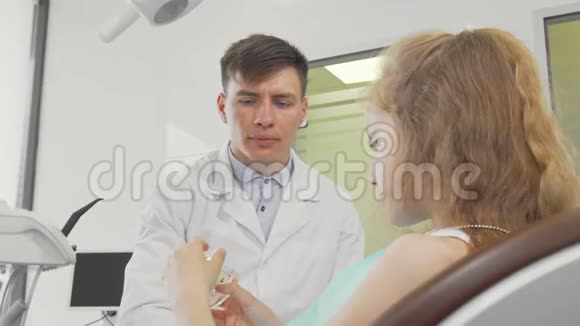专业牙医为他的年轻病人讲解牙科护理视频的预览图