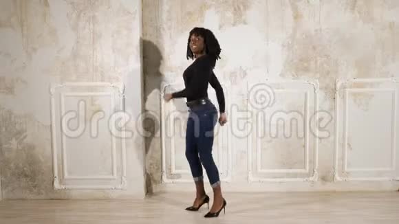 穿牛仔裤和套头衫的黑女人穿高跟鞋跳舞视频的预览图
