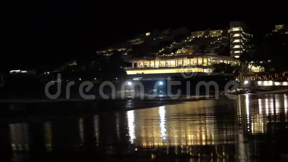 晚上在酒店背景下的海滩上带有城市夜景灯的海滨视频的预览图