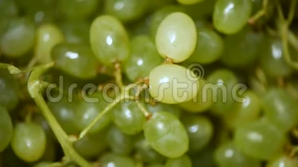 旋转背景上的新鲜绿色葡萄上景素和生食概念葡萄汁的质地视频的预览图