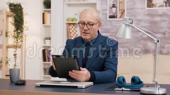在办公室坐下来的时候一个穿着平板电脑的人视频的预览图
