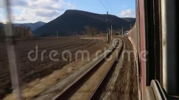 穿过风景从火车窗口观看快速骑行山脉视频的预览图