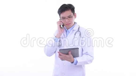 使用手机和数码平板电脑的快乐年轻亚洲男医生视频的预览图