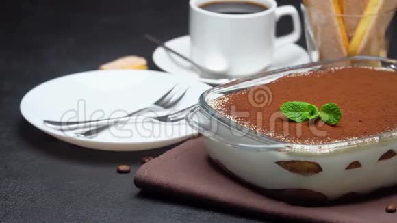 玻璃烤盘中的提拉米苏甜点浓缩咖啡杯和混凝土背景下的萨维亚迪视频的预览图