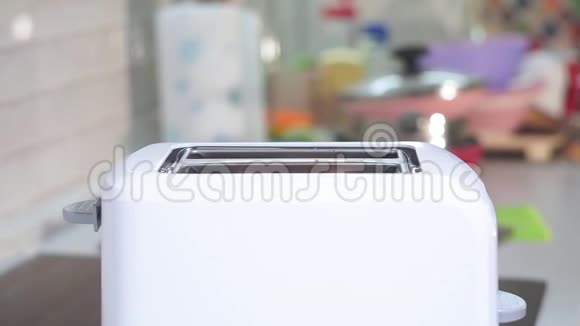白色吐司面包在两槽自动电动烤面包机为早餐做烤面包视频的预览图