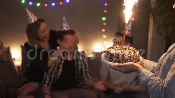 朋友们庆祝生日聚会令人惊讶的朋友用燃烧的闪闪发光的棍子蛋糕超级兴奋的笑视频的预览图