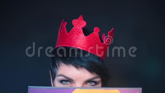 在黑色背景下一双红色皇冠上的爱情女孩的眼睛特写视频的预览图