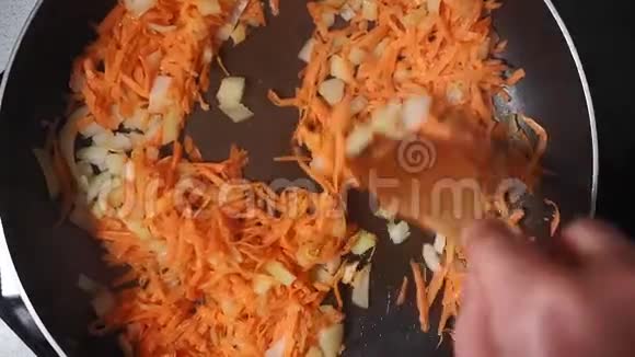 生胡萝卜和洋葱用葵花籽油煎锅视频的预览图