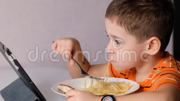 孩子们在餐桌上玩意大利面凌乱的脸吃饭酱汁和孩子男孩坐在托儿所吃面条视频的预览图