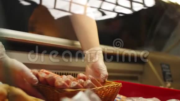 女售货员把美味的香肠放在杂货店的橱窗里视频的预览图