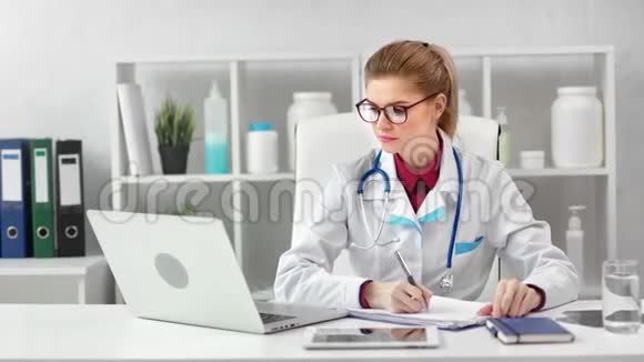 热情的年轻女医务工作者看着笔记本电脑屏幕注意事项视频的预览图
