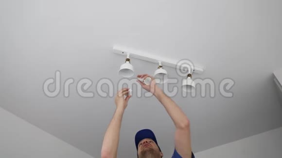 电工在天花板灯上安装LED灯泡视频的预览图
