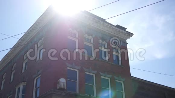 阳光明媚的下午美国小镇上一座红砖砌成的老银行大楼的一个固定镜头视频的预览图