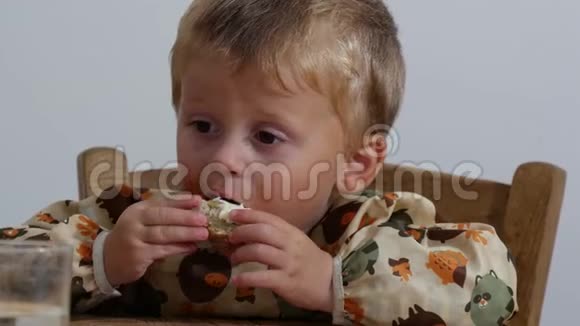 可爱的小男孩两年吃面包和奶酪视频的预览图