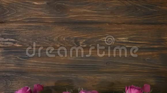 木制背景粉红色的花和复制空间的文字花店铺束玫瑰在木板上视频的预览图